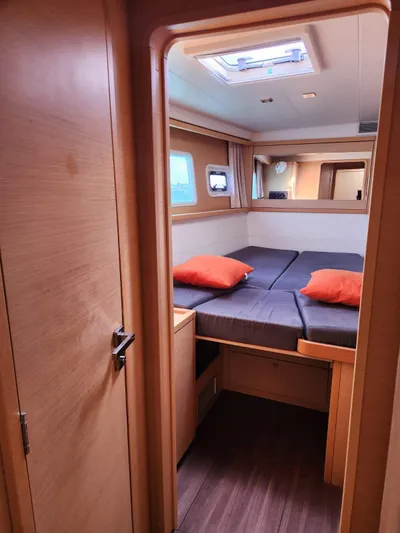  Yacht Photos Pics Interior cabin of 2012 Lagoon 450 F catamaran with cozy bed and orange pillows.