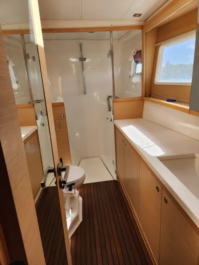  Yacht Photos Pics Interior of 2012 Lagoon 450 F yacht bathroom with wooden flooring and modern fixtures.