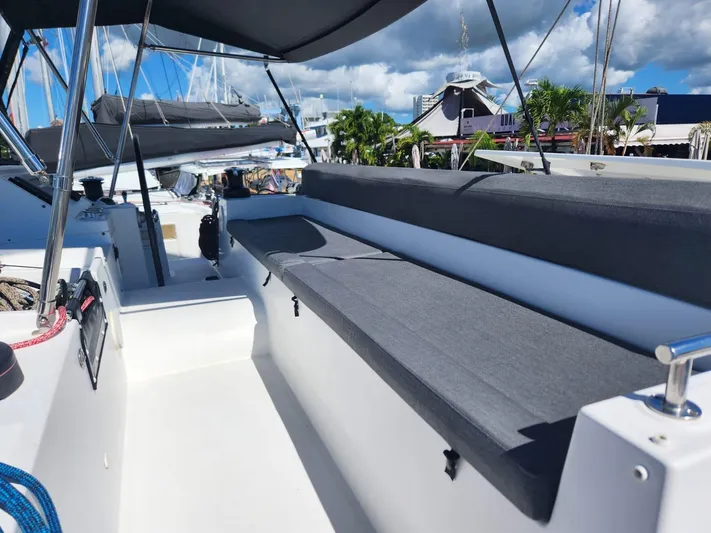  Yacht Photos Pics 2012 Lagoon 450 F catamaran deck with seating, under a sunny sky at the marina.