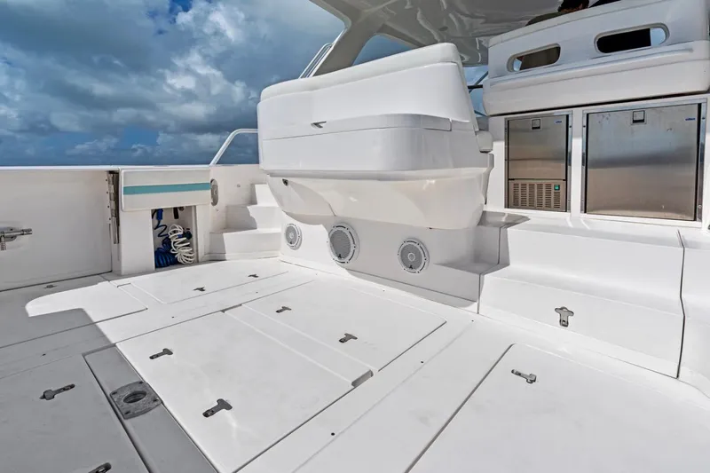  Yacht Photos Pics 2018 Intrepid 475 Sport Yacht deck with storage compartments and seating under a cloudy sky.