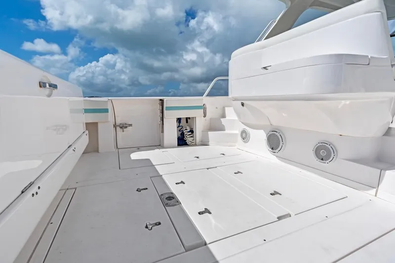  Yacht Photos Pics 2018 Intrepid 475 Sport Yacht deck with storage compartments under a cloudy sky.