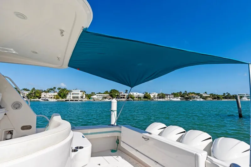  Yacht Photos Pics 2018 Intrepid 475 Sport Yacht with canopy, overlooking serene waterfront homes.