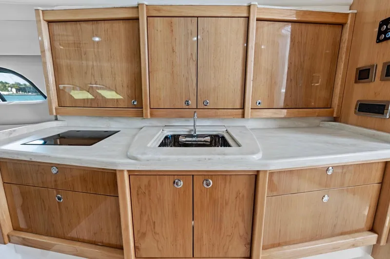  Yacht Photos Pics 2018 Intrepid 475 Sport Yacht kitchen with wooden cabinets and modern sink.