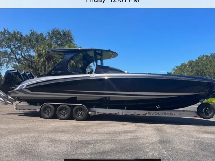  Yacht Photos Pics 2024 Mystic Powerboats M3800 on trailer, sleek black design, parked outdoors.