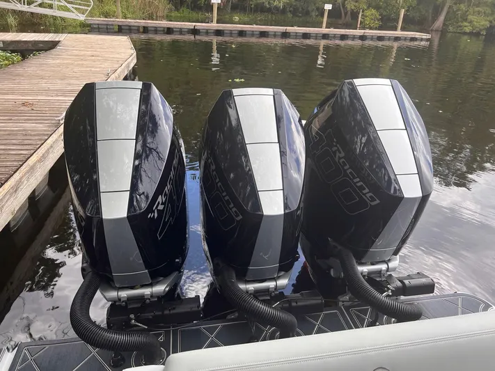  Yacht Photos Pics Triple outboard engines on a 2024 Mystic Powerboats M3800 at a dock.