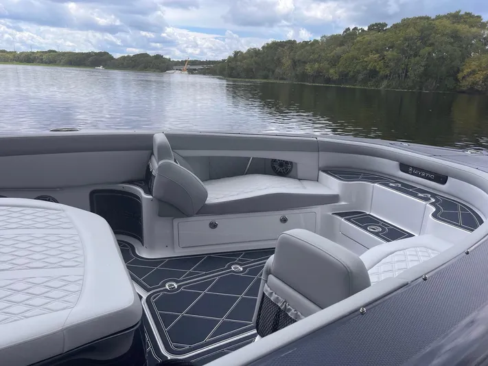  Yacht Photos Pics 2024 Mystic Powerboats M3800 interior with luxurious seating on a serene lake.