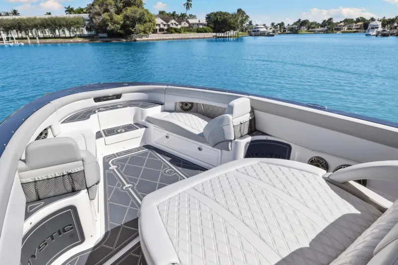  Yacht Photos Pics 2024 Mystic Powerboats M3800 interior with luxurious seating on a serene blue lake.
