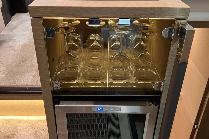  Yacht Photos Pics Glass cabinet with wine glasses above a mini fridge in a 2018 Prestige 520 yacht.