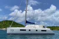 Sailing catamaran Nautitech 542, 2013 model, anchored in scenic tropical waters.