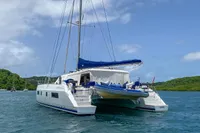 2013 Nautitech 542 catamaran anchored in scenic bay with lush green hills.