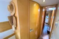 Interior hallway of 2013 Nautitech 542 yacht with wooden doors and straw hats.