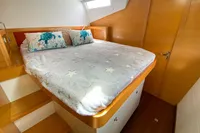 Cozy bedroom in 2013 Nautitech 542 yacht with star-patterned bedding and sea-themed pillows.