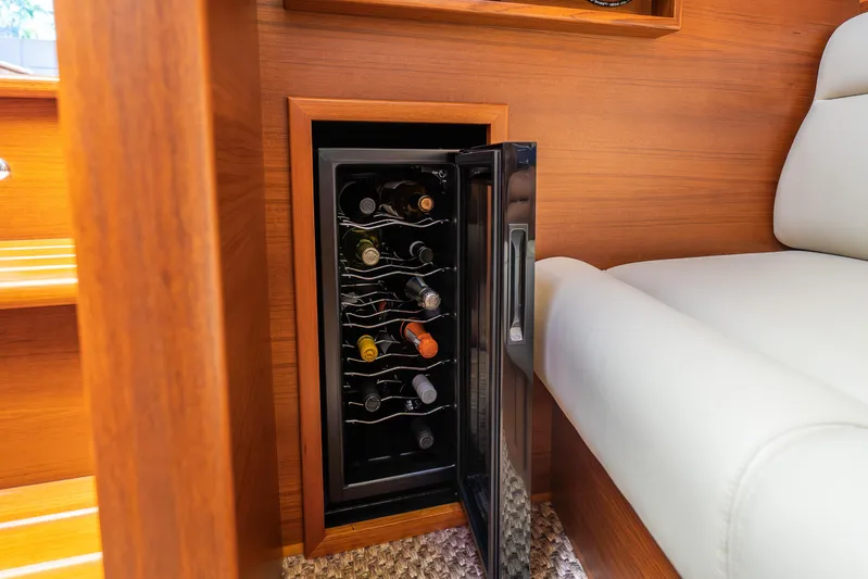 Pitt Stop Yacht Photos Pics Luxury yacht PB55 interior with wine cooler, wooden finish, and white seating, 2020 model.