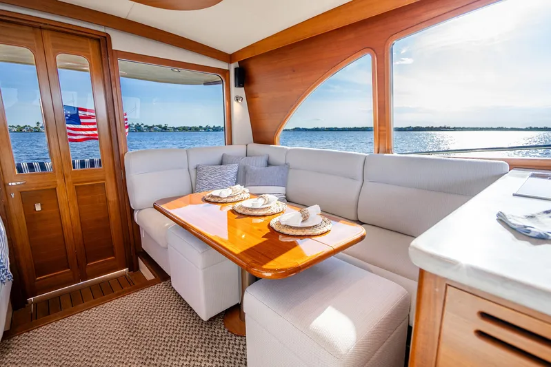 Pitt Stop Yacht Photos Pics Luxurious interior of 2020 Palm Beach Motor Yachts PB55 with elegant dining area and scenic view.