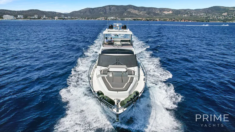  Yacht Photos Pics 2021 Galeon 680 Fly yacht cruising on open sea with scenic coastal backdrop.
