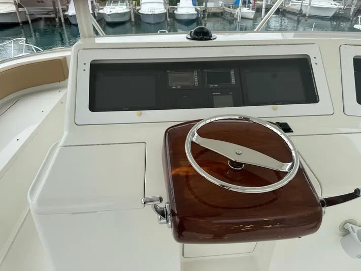  Yacht Photos Pics 2010 Viking 54 Convertible yacht helm with wooden steering wheel and navigation instruments.
