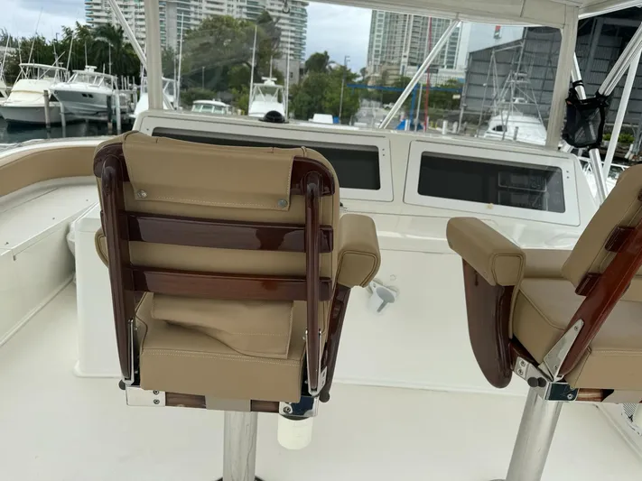  Yacht Photos Pics 2010 Viking 54 Convertible yacht helm station with leather seats and marina background.