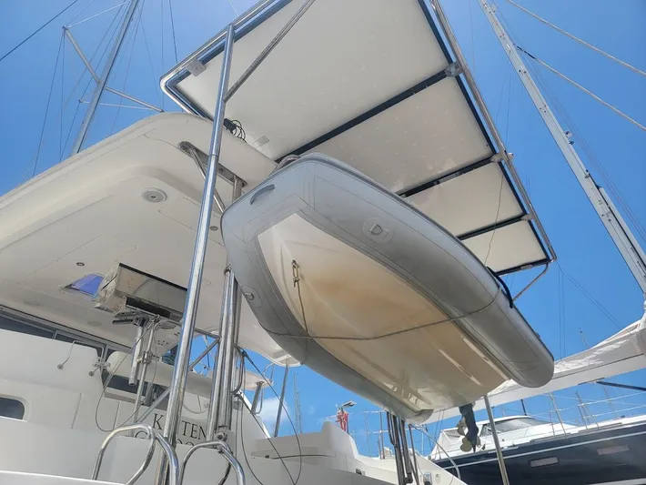 Kitten Caboodle Yacht Photos Pics 2015 Leopard 44 catamaran with dinghy, viewed from below against a clear blue sky.