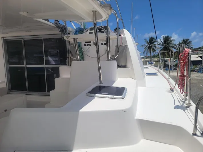 Kitten Caboodle Yacht Photos Pics Leopard 44 catamaran deck, 2015 model, featuring helm station and tropical marina backdrop.