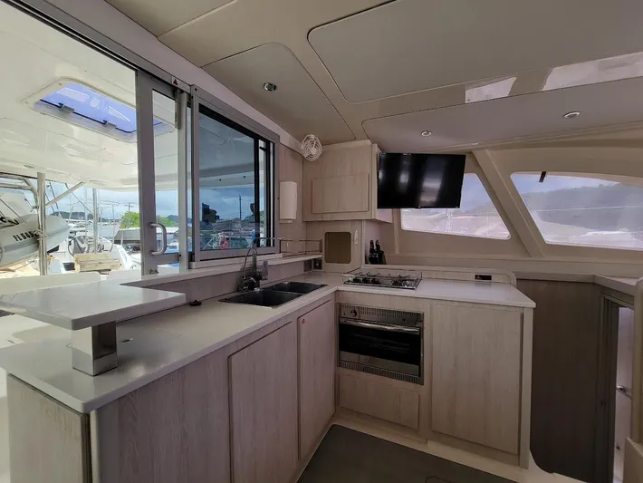 Kitten Caboodle Yacht Photos Pics Modern kitchen interior of 2015 Leopard 44 catamaran with appliances and large windows.