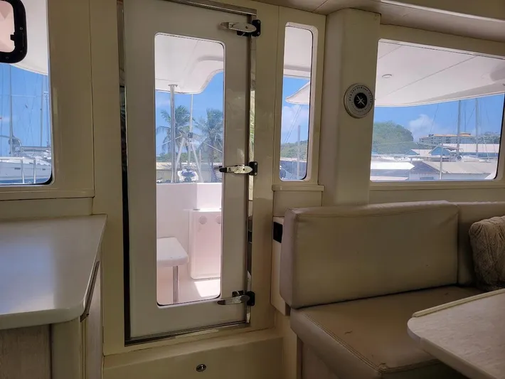 Kitten Caboodle Yacht Photos Pics Interior view of 2015 Leopard 44 catamaran, featuring seating and door to deck.