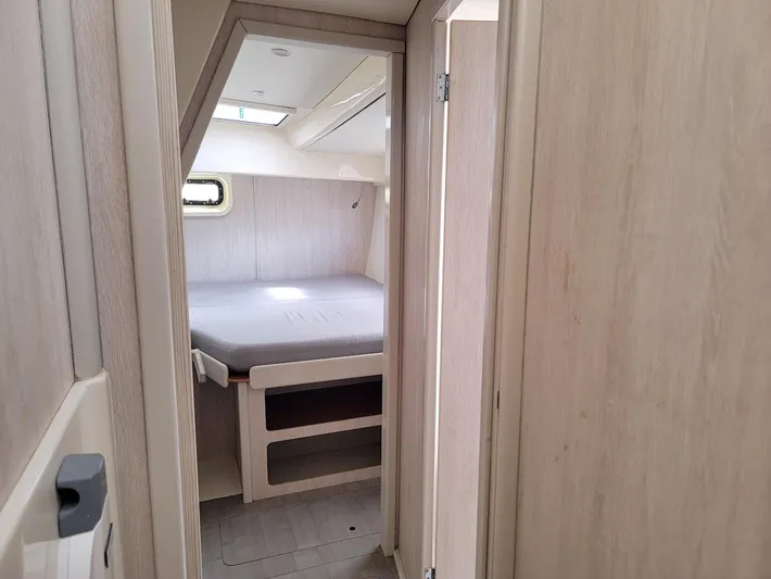 Kitten Caboodle Yacht Photos Pics Cabin interior of a 2015 Leopard 44 catamaran, featuring a cozy bed and wooden finish.