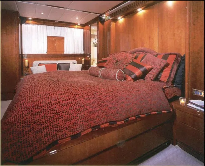  Yacht Photos Pics Luxurious yacht bedroom with red bedding, wood paneling, and ambient lighting, Tecnomarine 1993 model.