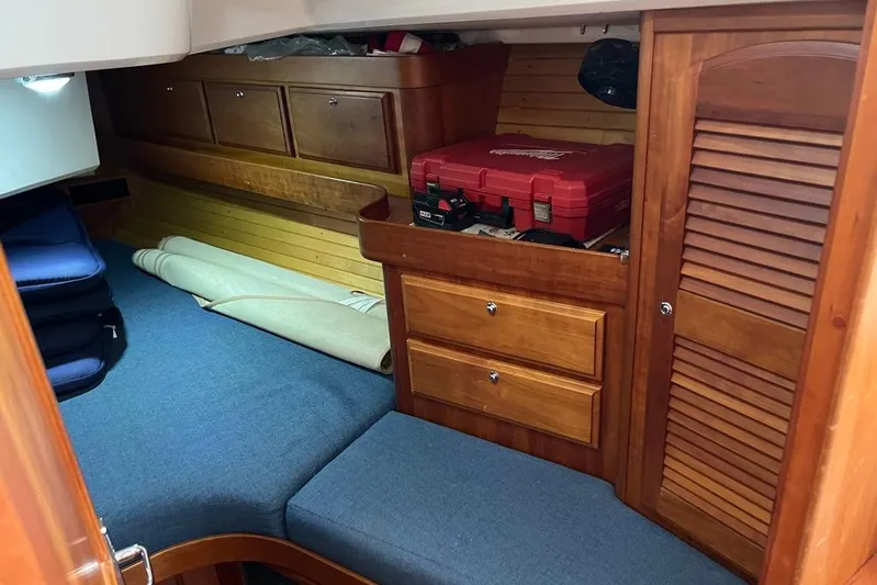  Yacht Photos Pics Cozy cabin interior of 2002 Sabre 402 sailboat with wooden storage and blue cushions.