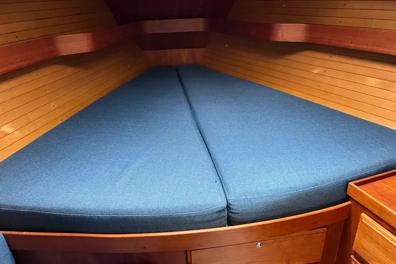  Yacht Photos Pics Cozy cabin interior of 2002 Sabre 402 sailboat with blue cushions and wooden paneling.