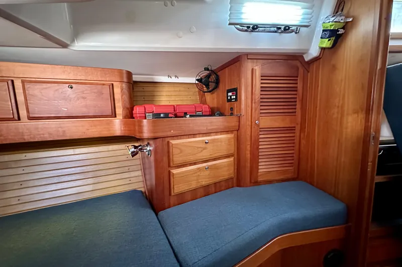  Yacht Photos Pics Interior cabin of a 2002 Sabre 402 yacht with wooden cabinetry and blue cushions.