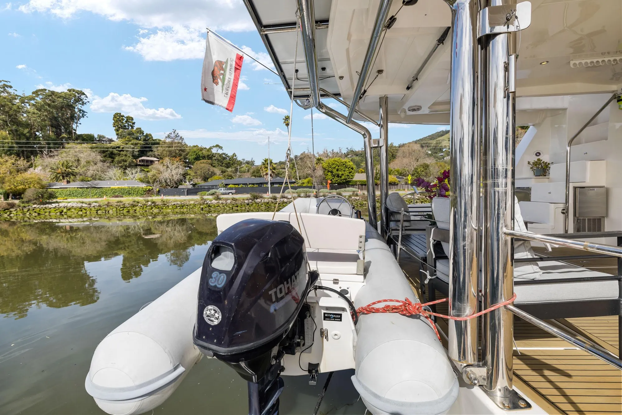 Luxury Leopard 58 yacht deck with inflatable boat and scenic waterfront view.