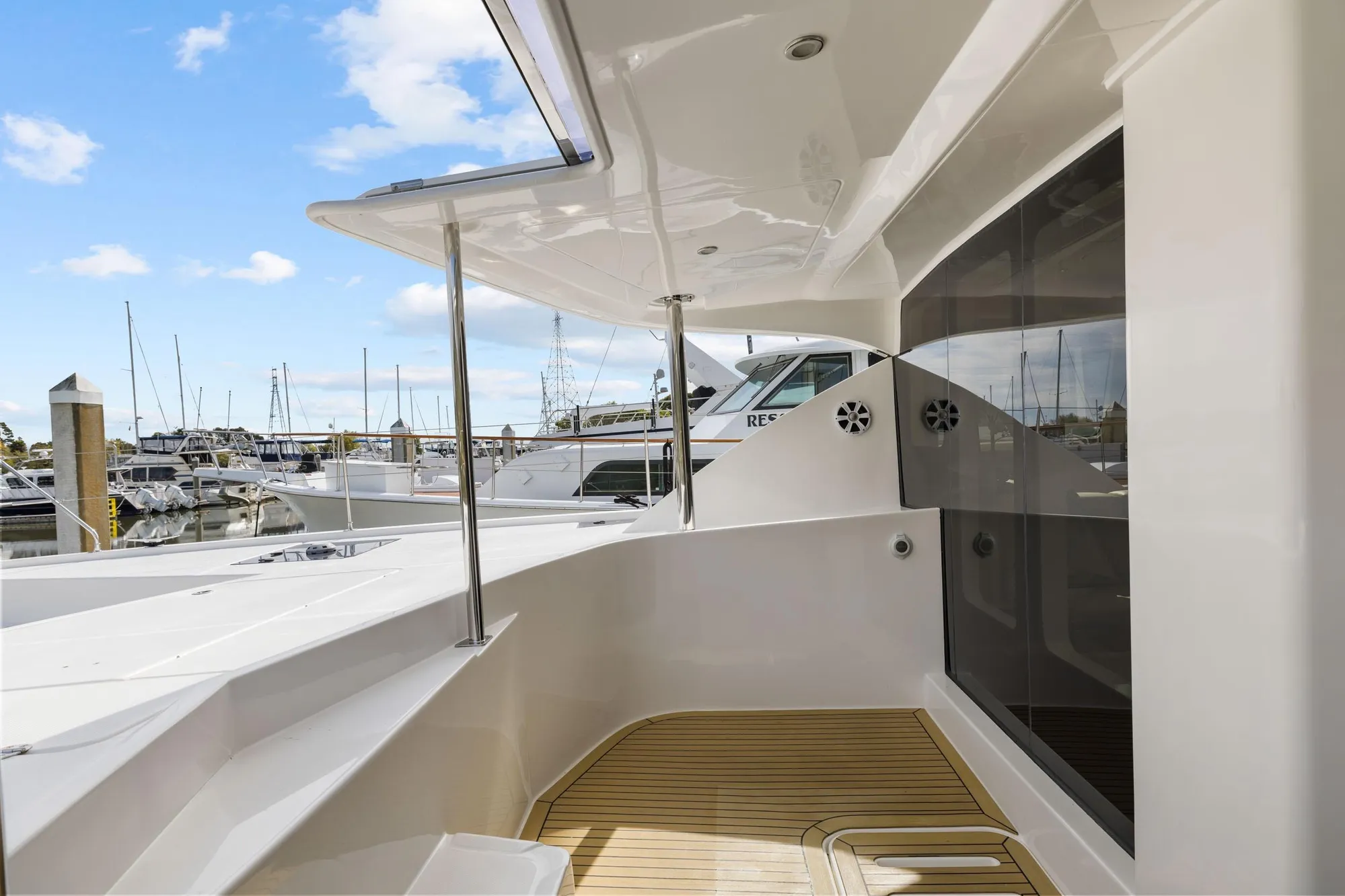 Luxury Leopard 58 yacht deck, 2015 model, docked at marina with clear blue sky.