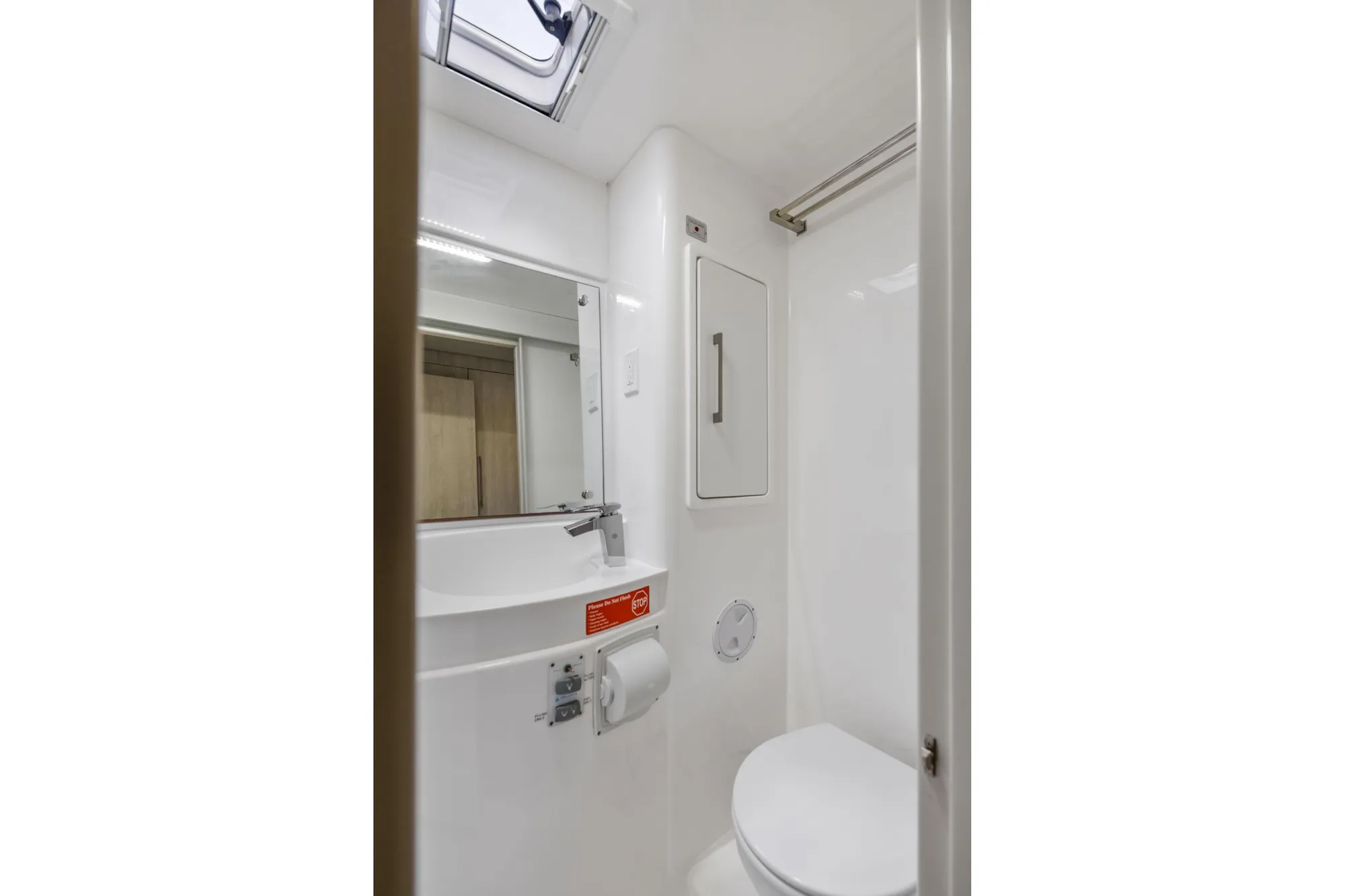 Compact bathroom in 2015 Leopard 58 yacht with modern fixtures and skylight.