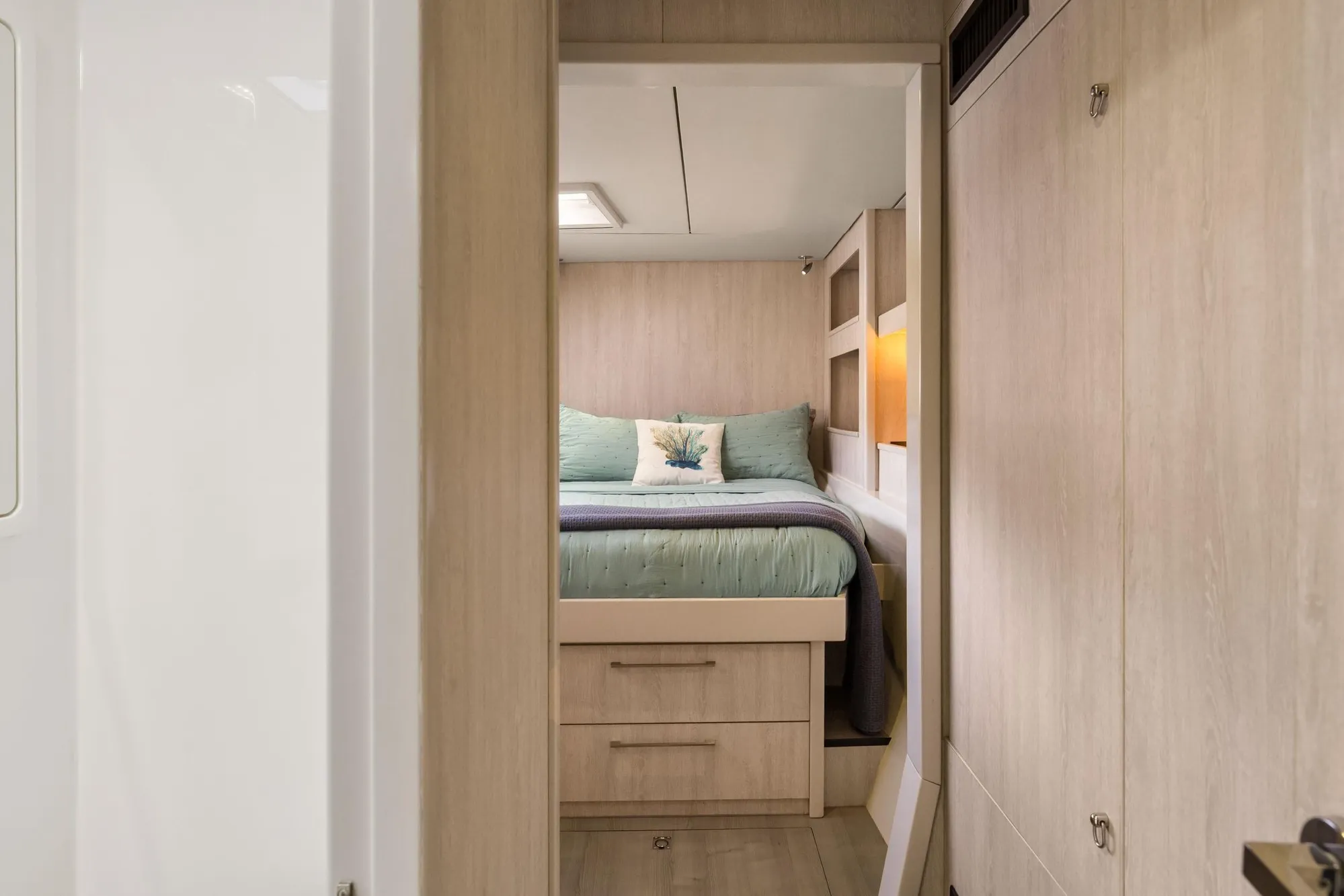 Luxurious bedroom interior of 2015 Leopard 58 yacht with modern wood finish.