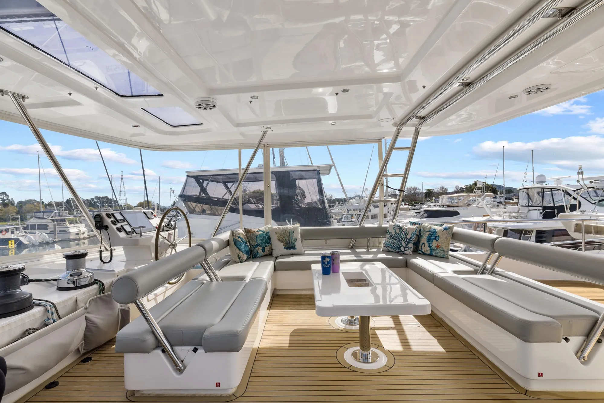 Luxurious 2015 Leopard 58 yacht interior with seating, table, and marina view.