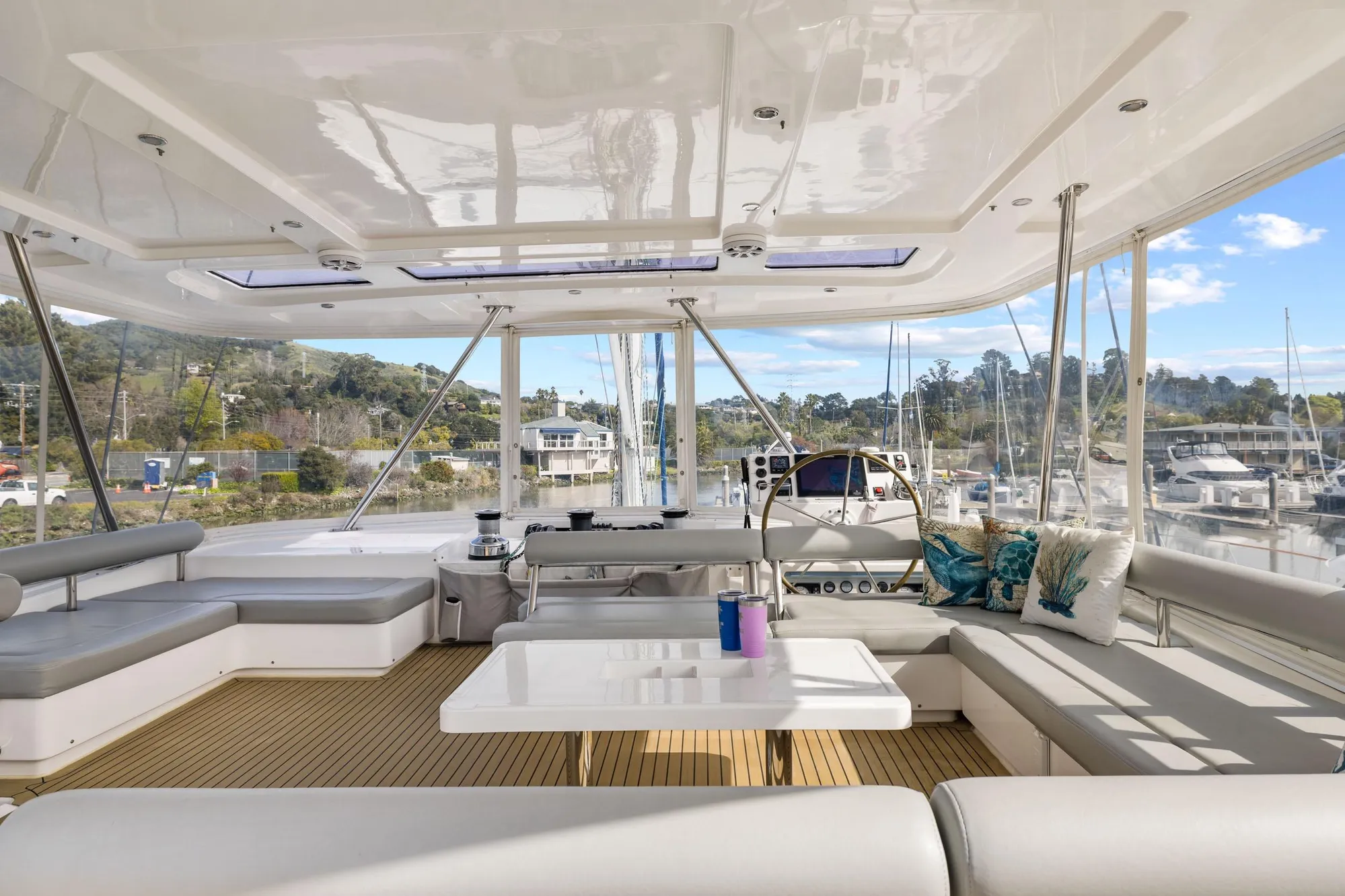 Luxurious 2015 Leopard 58 yacht interior with spacious seating and scenic marina view.
