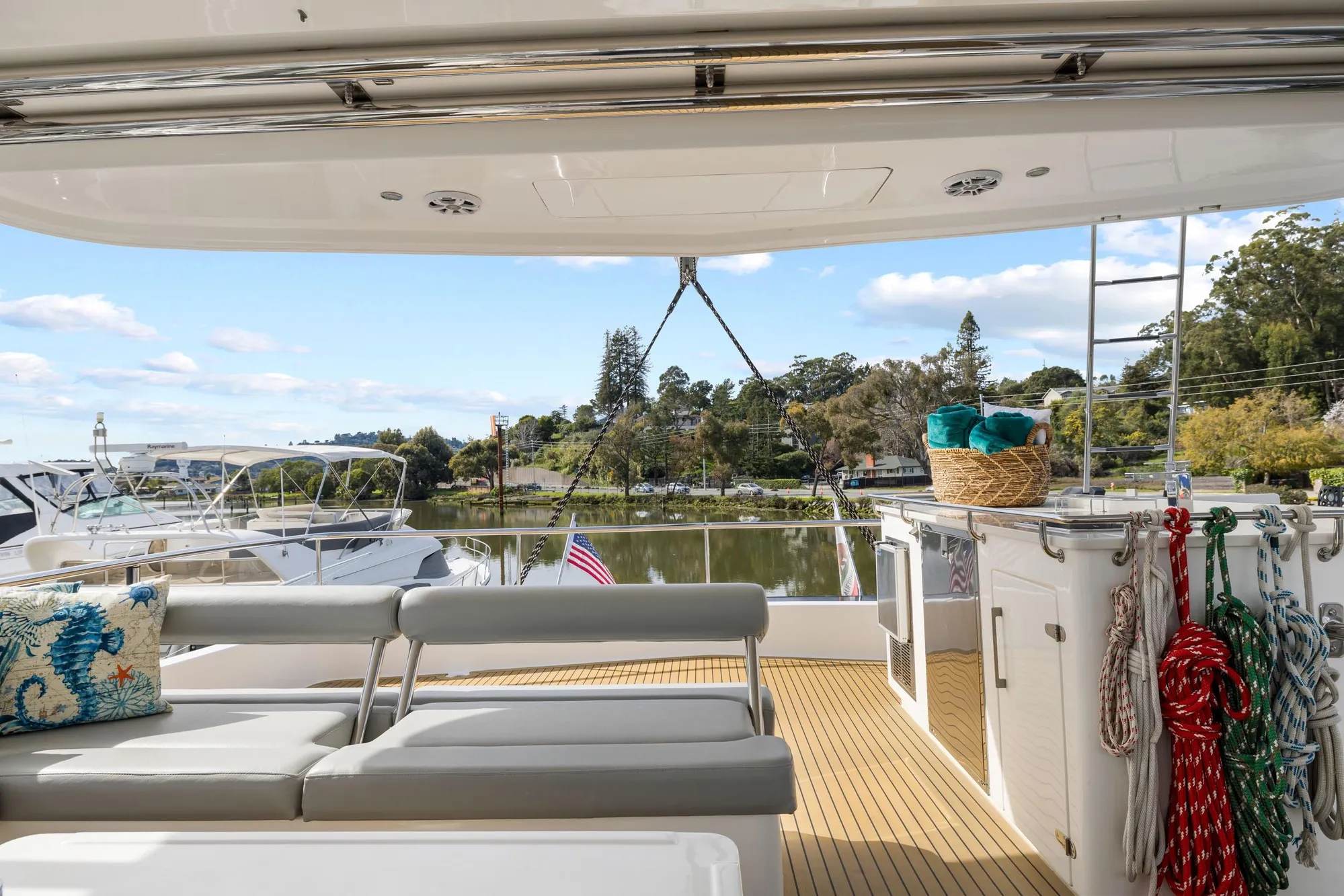 Luxurious 2015 Leopard 58 yacht deck with seating, ropes, and scenic waterfront view.