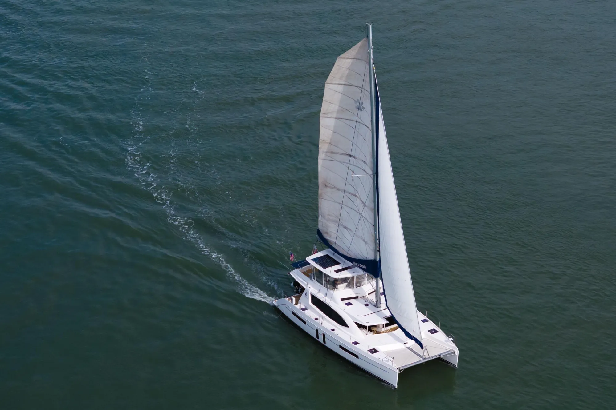 Aerial view of 2015 Leopard 58 catamaran sailing on open water.
