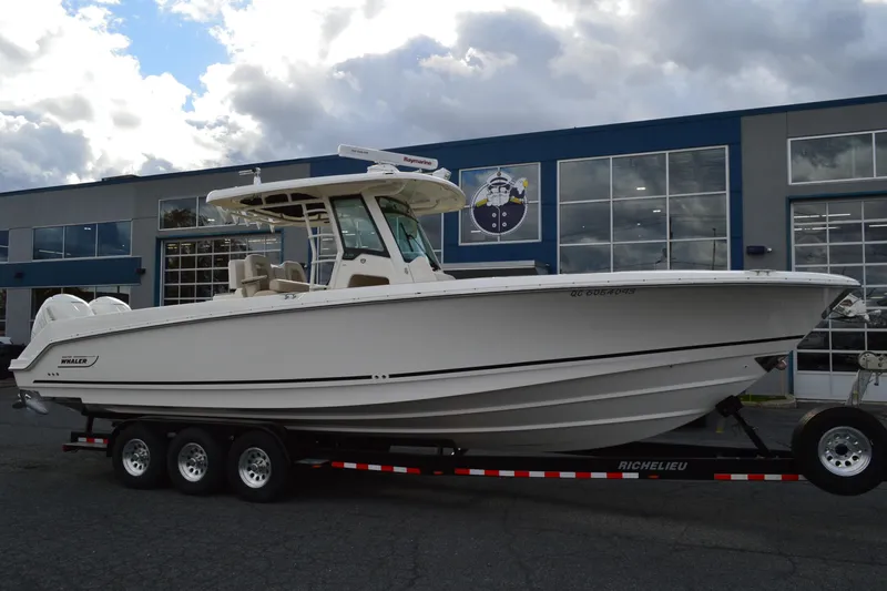  Yacht Photos Pics 2018 Boston Whaler 330 Outrage boat on trailer, parked outside a building.