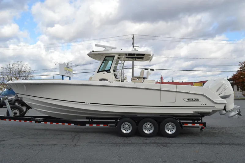  Yacht Photos Pics 2018 Boston Whaler 330 Outrage boat on trailer under cloudy sky.