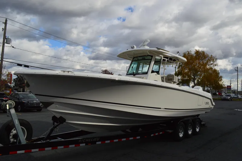  Yacht Photos Pics 2018 Boston Whaler 330 Outrage boat on trailer under cloudy sky.