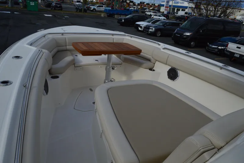  Yacht Photos Pics 2018 Boston Whaler 330 Outrage boat interior with seating and wooden table.