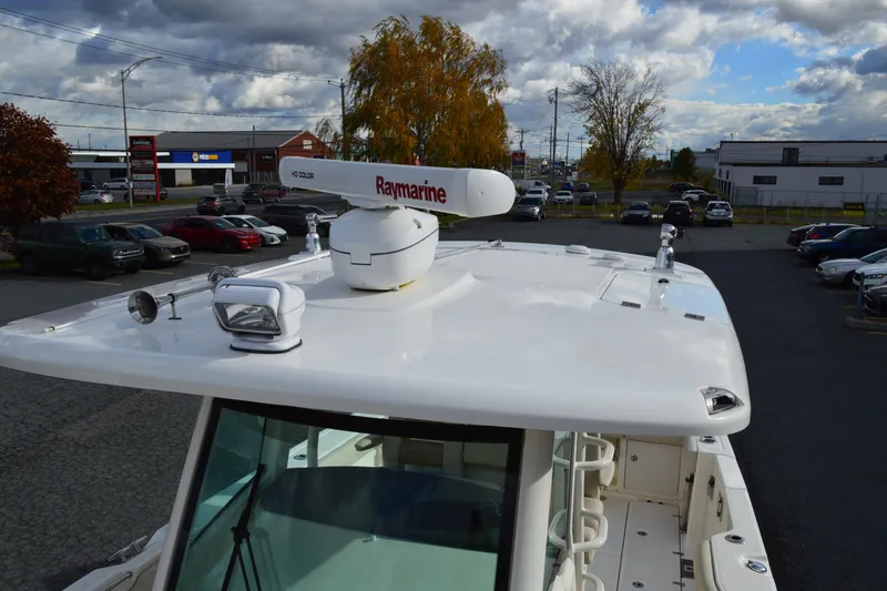  Yacht Photos Pics 2018 Boston Whaler 330 Outrage boat with Raymarine radar, parked in a lot under cloudy sky.