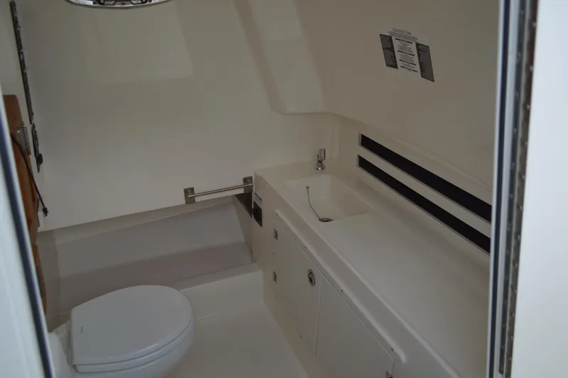  Yacht Photos Pics Interior of 2018 Boston Whaler 330 Outrage boat bathroom with sink and toilet.