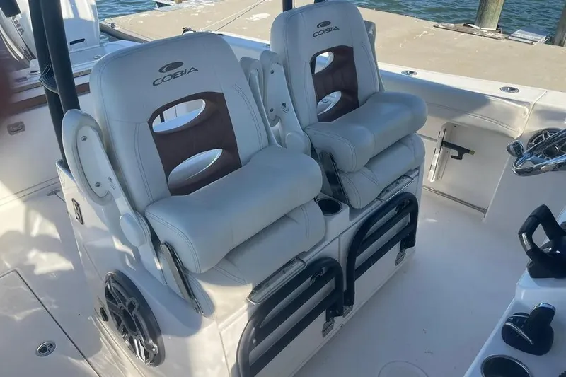  Yacht Photos Pics 2023 Cobia 320 Center Console boat interior with dual cushioned seats and steering area.