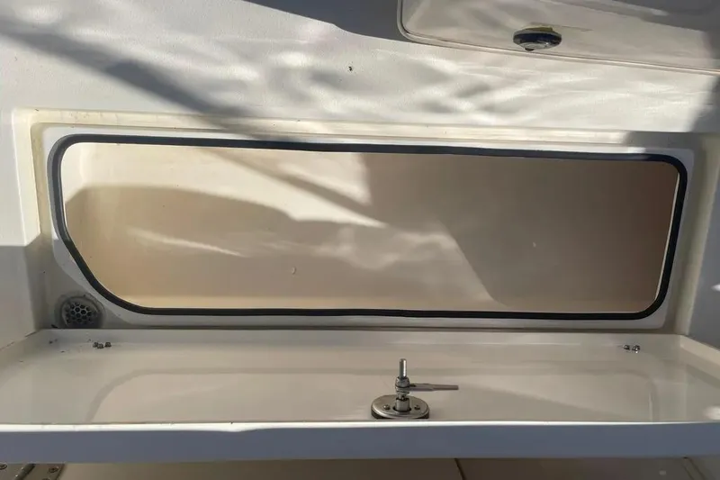  Yacht Photos Pics 2023 Cobia 320 Center Console storage compartment with latch, interior view.