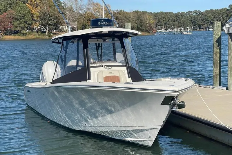  Yacht Photos Pics 2023 Cobia 320 Center Console boat docked on a serene lake.