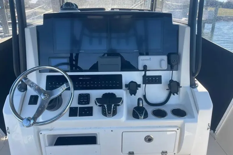  Yacht Photos Pics 2023 Cobia 320 Center Console helm with steering wheel, Garmin displays, and control panel.