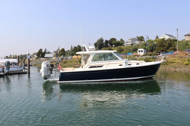 Naut On Call Yacht Photos Pics 2016 Back Cove 34 boat docked in a scenic marina setting.