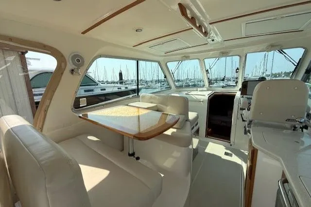 Naut On Call Yacht Photos Pics 2016 Back Cove 34 yacht interior with elegant seating and dining area, marina view.